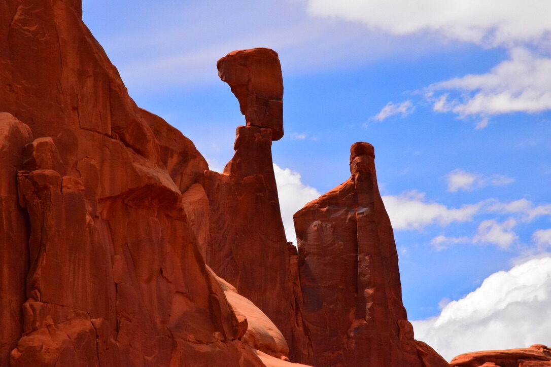 Balanced spire rock formations against a blue sky in Arches National Park
