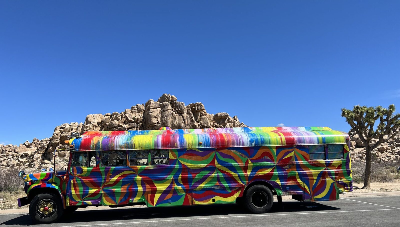 SUGAREE parked in Joshua Tree, full mandala paint job under a clear desert sky