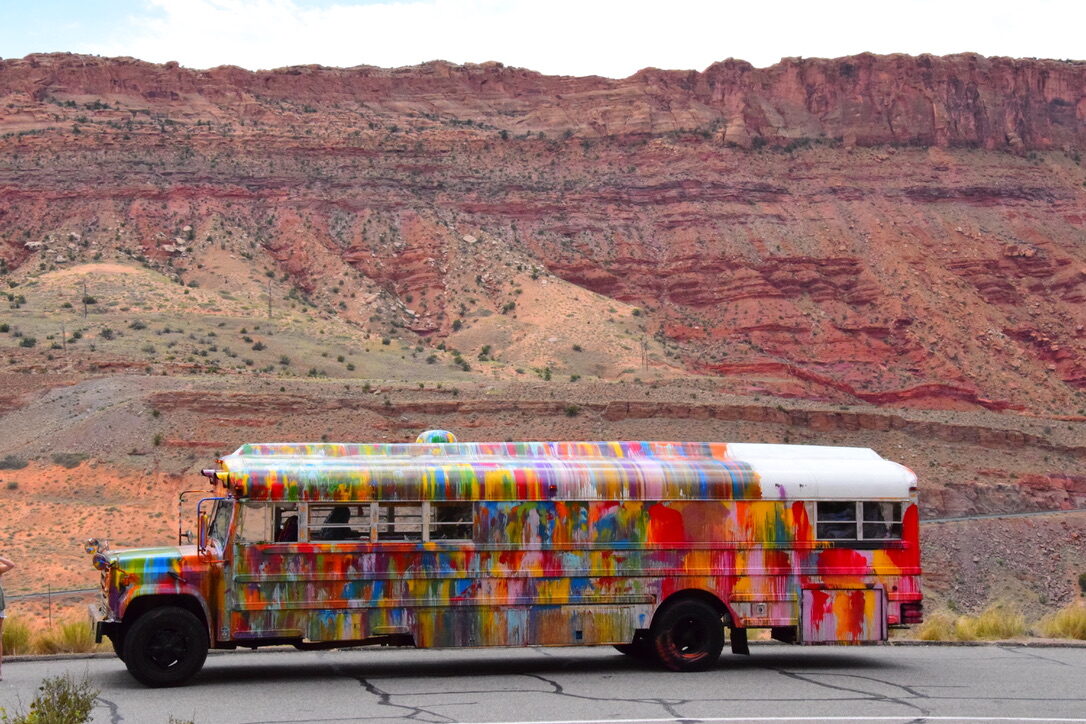 Side view of SUGAREE parked in front of a red rock cliff