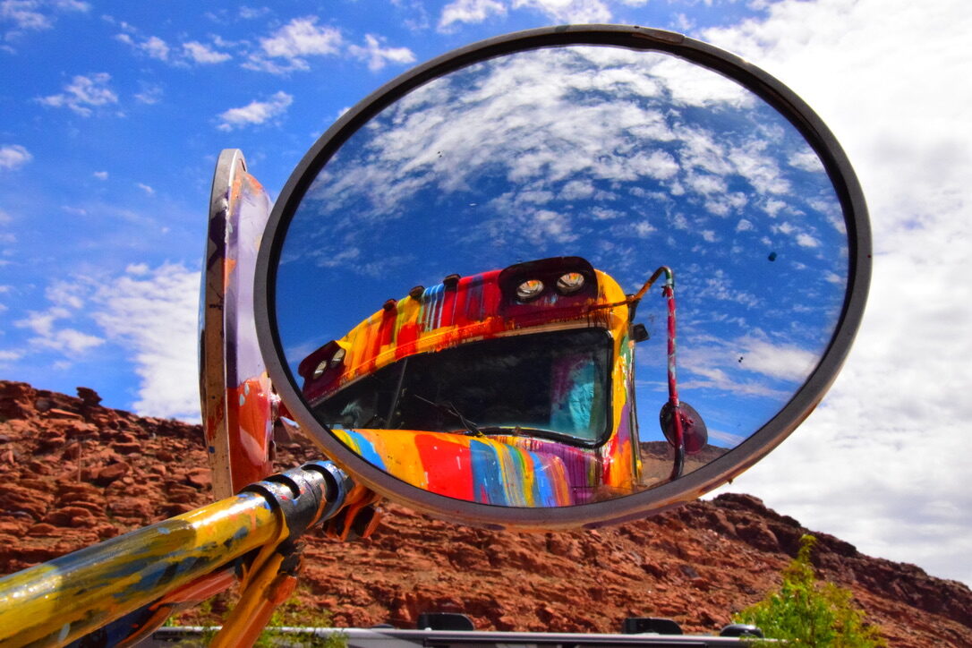 SUGAREE's side mirror reflecting red rock desert terrain