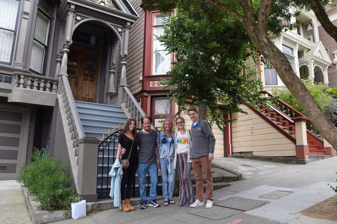 The family standing on the steps of a Haight-Ashbury Victorian house