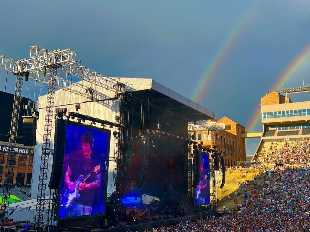 A double rainbow arcing over the stage at Folsom Field during a show