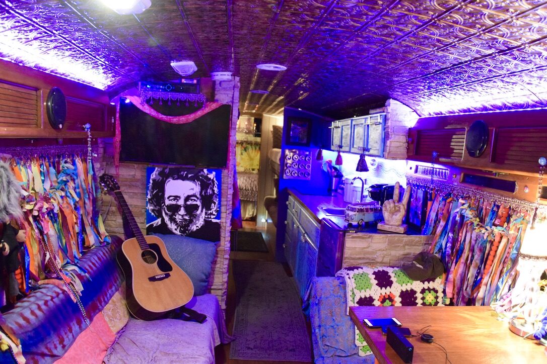 A guitar resting beside a Jerry Garcia portrait inside SUGAREE