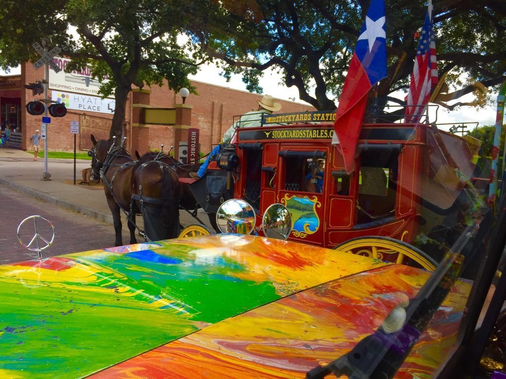 SUGAREE's peace-sign hood ornament with the Fort Worth Stockyards Station stagecoach behind it