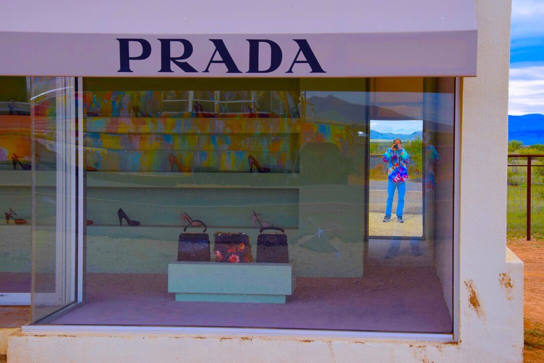 Close-up of the Prada Marfa storefront window, SUGAREE reflected in the glass