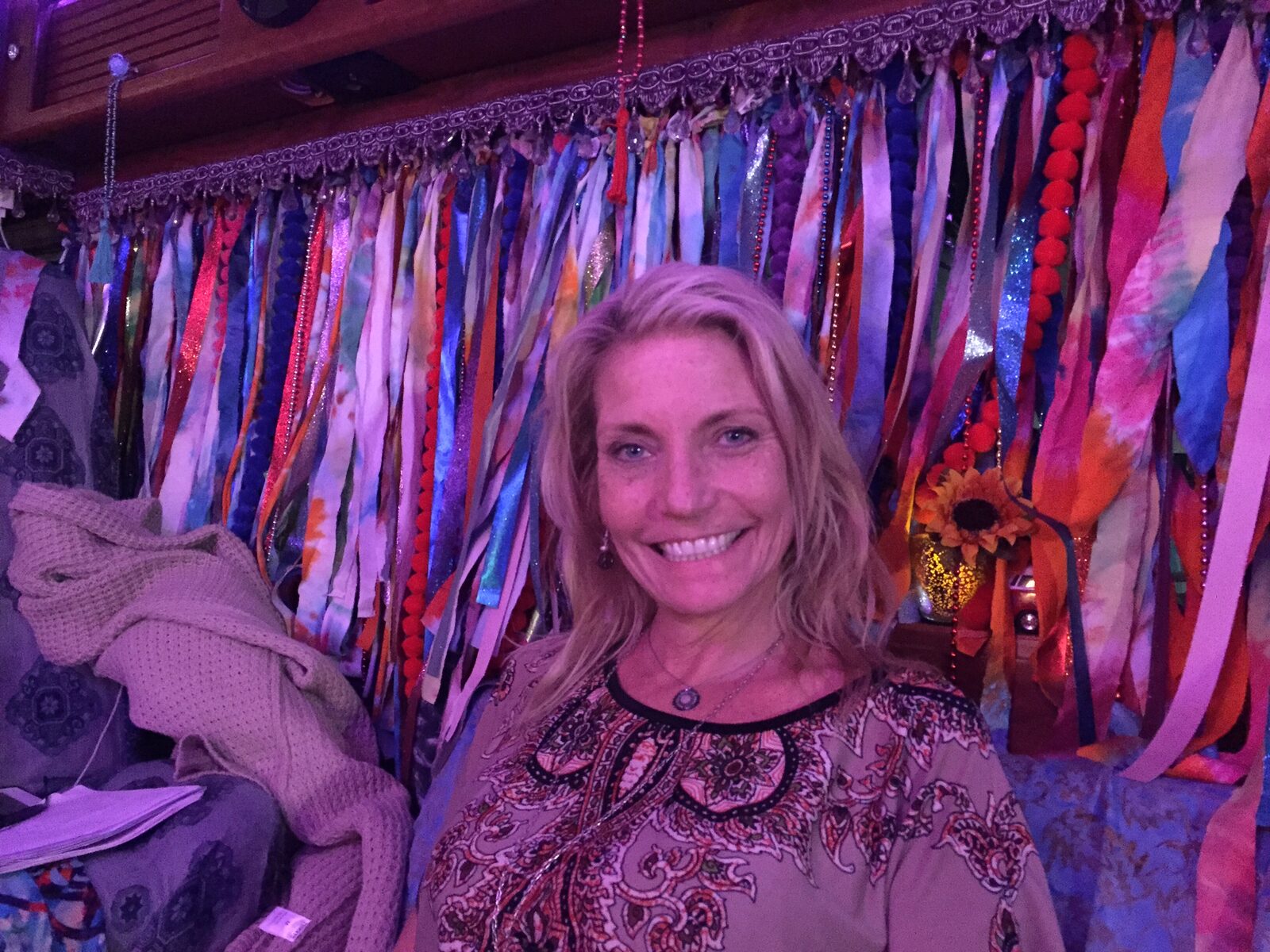 A close-up portrait of a woman in front of SUGAREE's ribbon curtains