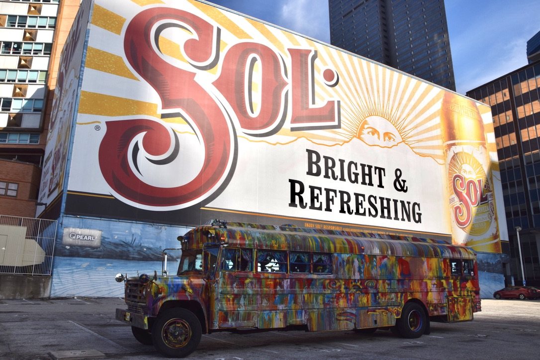 SUGAREE parked beneath a large painted wall mural in the city