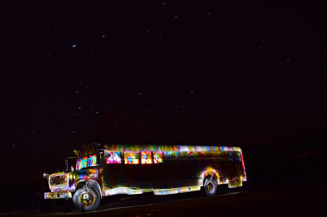 SUGAREE glowing in rainbow light painting beneath a star-trail sky