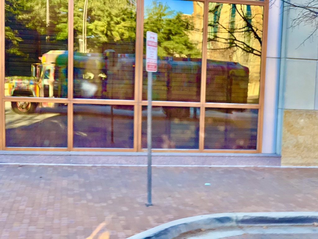 SUGAREE reflected in a downtown storefront window
