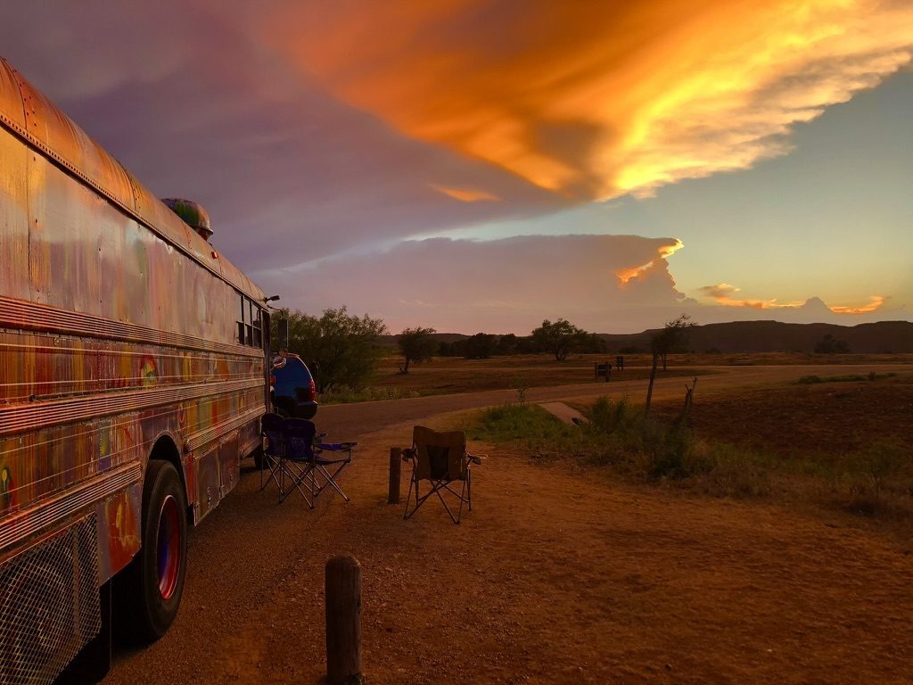 SUGAREE parked at camp under a dramatic orange sunset