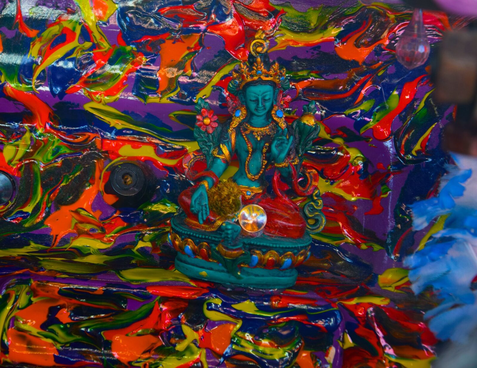 A small teal Tara figurine mounted on SUGAREE's paint-swirled interior panel