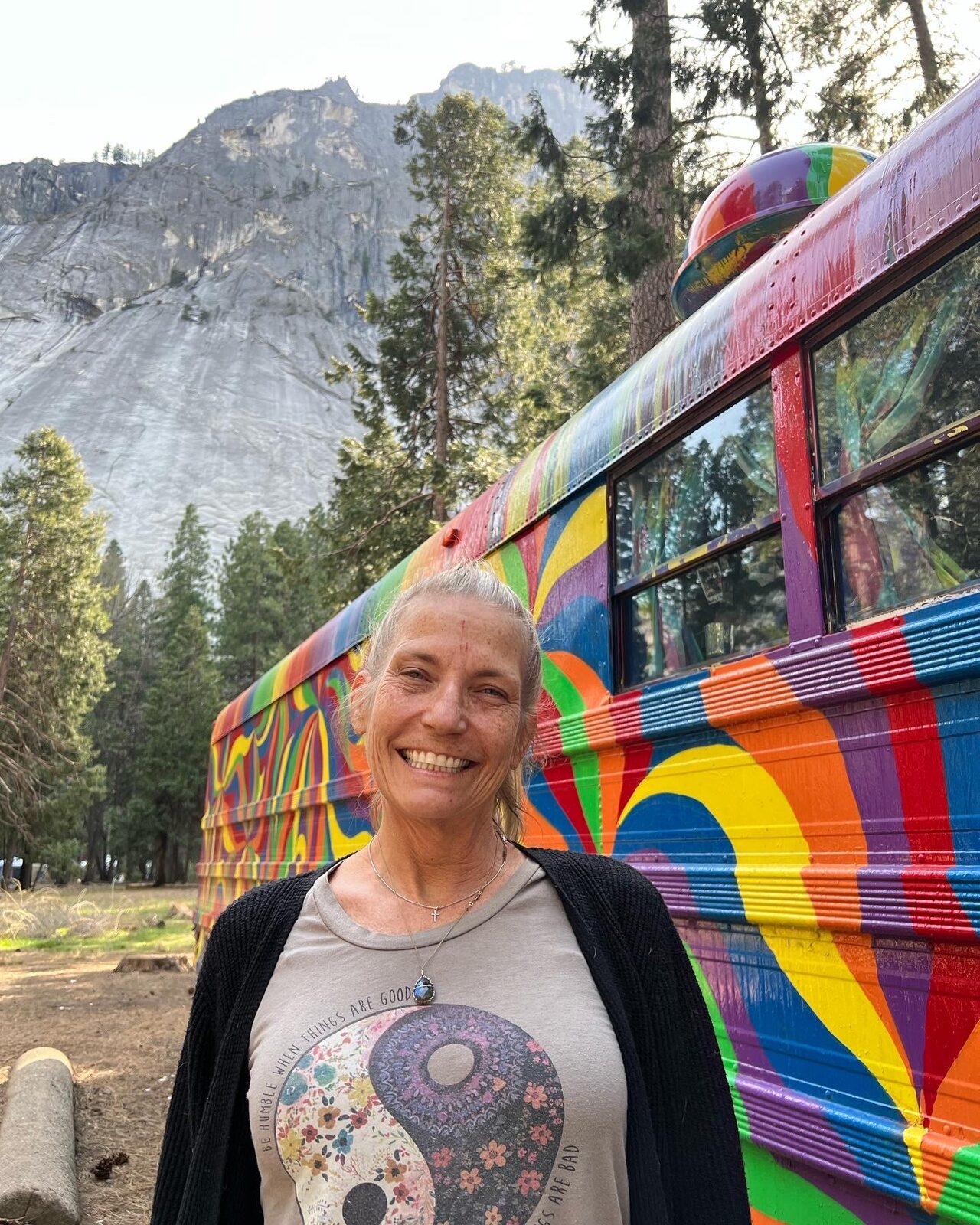 A woman smiling in front of SUGAREE, granite cliffs of Yosemite Valley behind