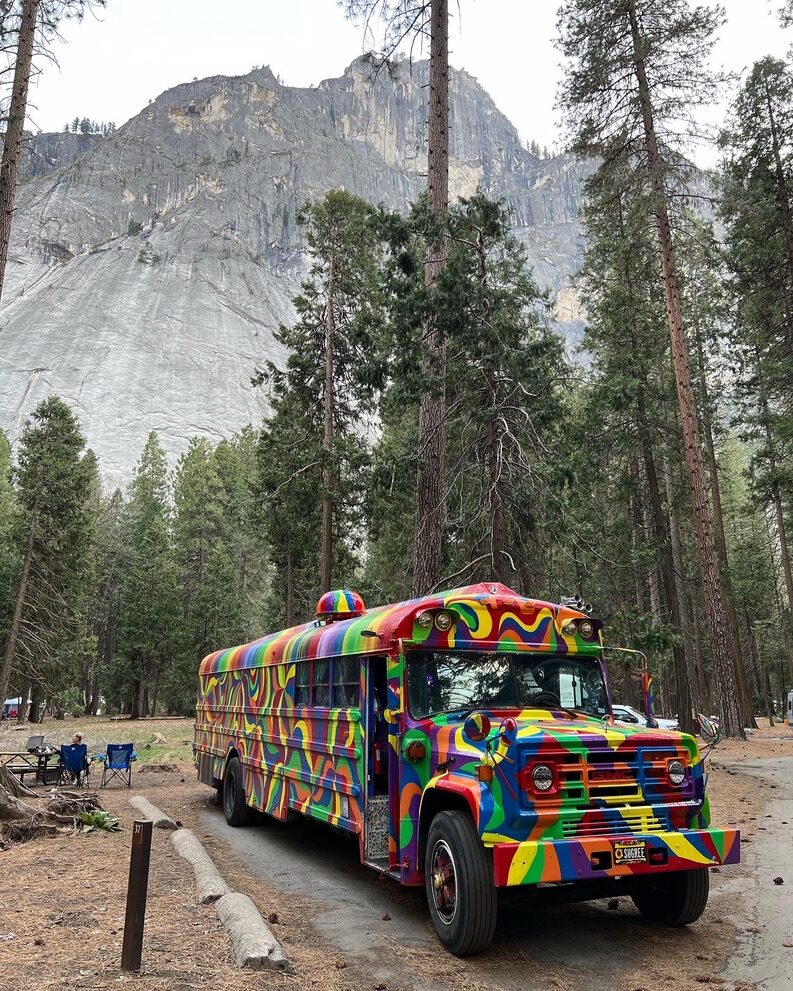 SUGAREE parked among tall pines with a granite cliff and waterfall in Yosemite Valley behind it